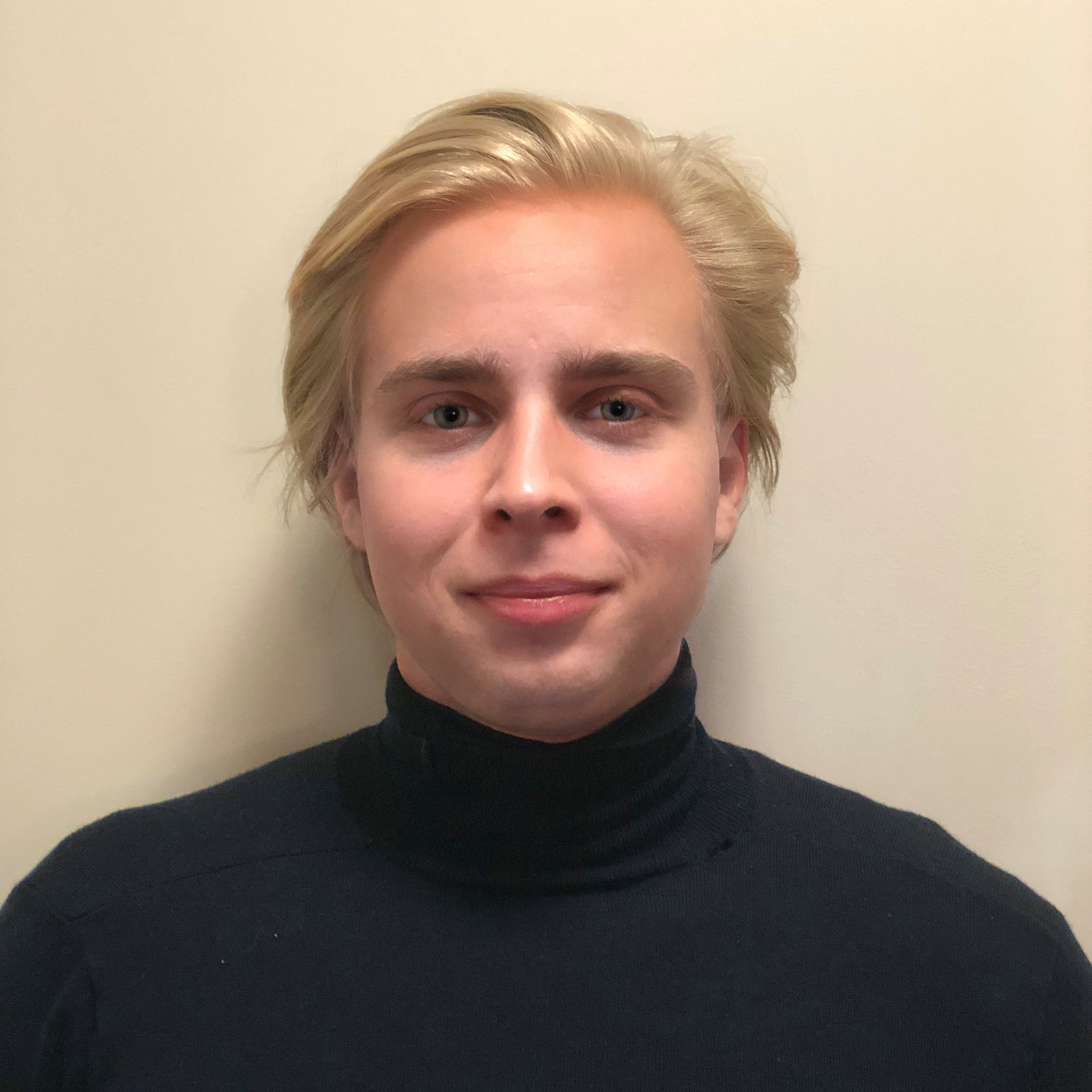 Headshot of Marcin wearing a black turtleneck
