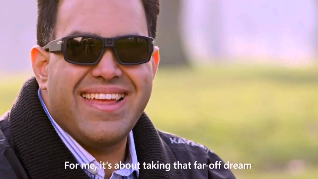 Saqib Shaikh a software engineer at Microsoft, wearing the SeeingAI glasses with the text saying 'For me, it's about taking that far-off dream